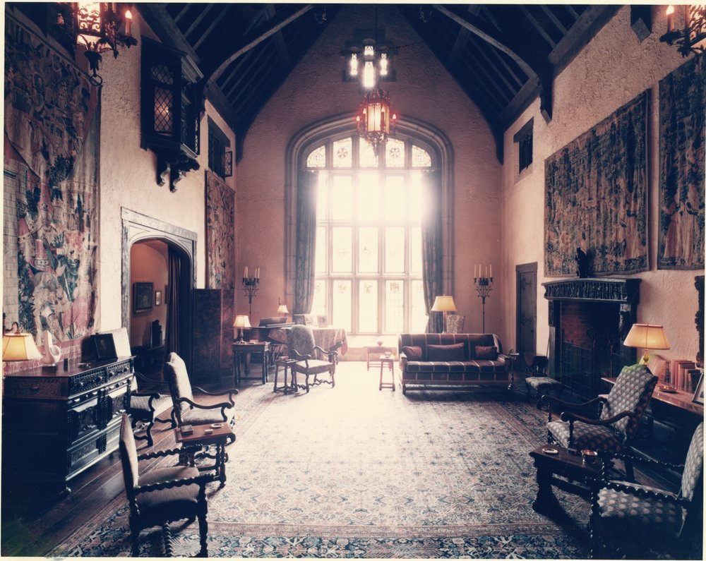View of the hall's arched window, ornate tapestries, and paintings encompassing the space, ca. 1960s